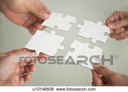 Stock Photo - Hands holding puzzle pieces. Fotosearch