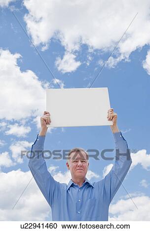 Man holding a blank sign View Large Photo Image Stock Image - Man holding a blank sign. Fotosearch