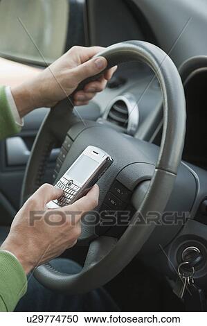 Man using personal digital assistant while driving View Large Photo Image Stock Image - Man using personal digital assistant while driving. Fotosearch