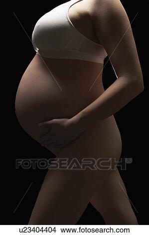 Picture - Pregnant woman holding belly. Fotosearch