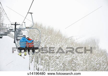 Stock Image - Skiers on a ski lift. Fotosearch