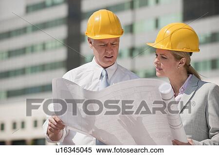 Stock Photography - Two architects holding plans outdoors. Fotosearch