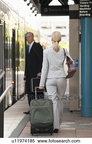 Stock Photography - Two business people at a train station. Fotosearch