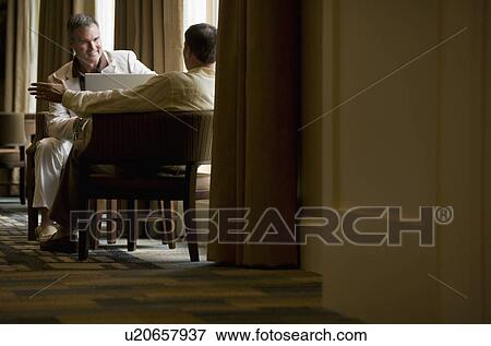 Two business people in a lobby View Large Photo Image Stock Photo - Two business people in a lobby. Fotosearch