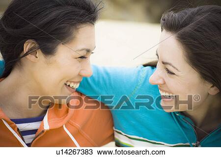 Stock Image - Two girl friends at the beach. Fotosearch