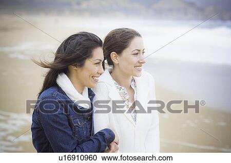 Stock Image - Two girl friends at the beach. Fotosearch