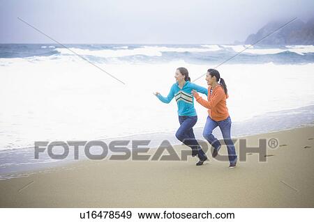 Stock Photo - Two girl friends at the beach. Fotosearch