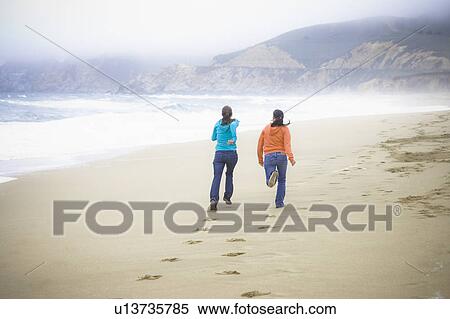 Stock Photography - Two girl friends at the beach. Fotosearch