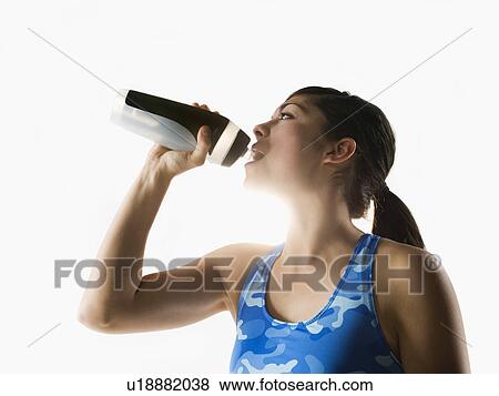 Woman drinking water while training View Large Photo Image Stock Photo - Woman drinking water while training. Fotosearch