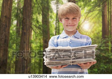 Picture - Young boy with stack of newspapers. Fotosearch