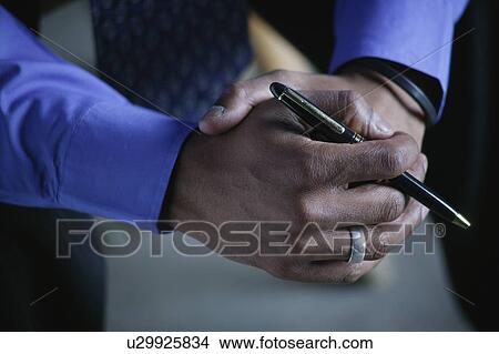 A businessman holds a pen View Large Photo Image Picture - A businessman holds a pen. Fotosearch