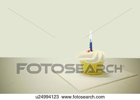 Stock Image - A cupcake with a candle. Fotosearch