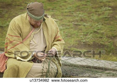 Stock Image - A fisherman working on net. Fotosearch