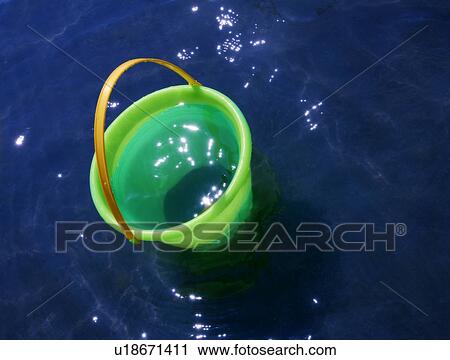 A sand bucket in the water View Large Photo Image Stock Image - A sand bucket in the water. Fotosearch