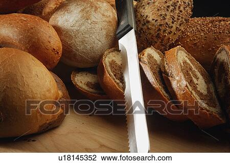 Stock Image - A selection of breads and a bread knife. Fotosearch
