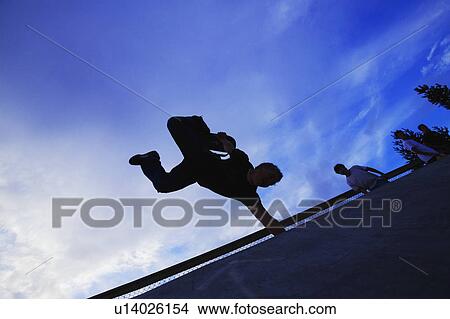 A skateboarder does a trick View Large Photo Image Picture - A skateboarder does a trick. Fotosearch