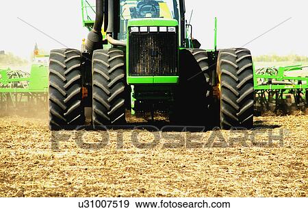 Stock Photo - A tractor in a field. Fotosearch