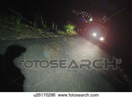 Stock Photograph - A vehicle's headlights at night. Fotosearch