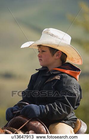 Stock Image - A young cowboy on cattle round up in Southern Alberta Canada. Fotosearch