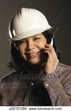 Aboriginal female site worker on cell phone View Large Photo Image Picture - Aboriginal female site worker on cell phone. Fotosearch