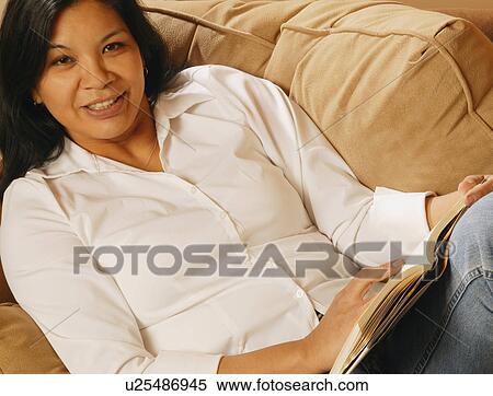 Stock Photography - Attractive woman relaxing and reading. Fotosearch