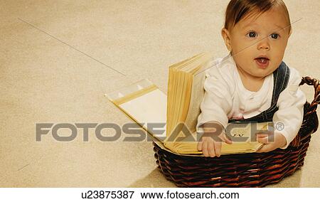 Baby reading a book in a basket View Large Photo Image Stock Photo - Baby reading a book in a basket. Fotosearch