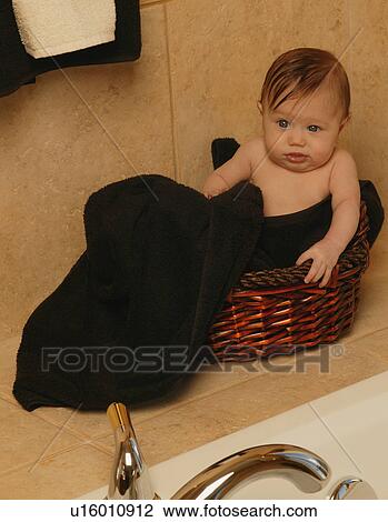 Baby sits in bathroom basket View Large Photo Image Stock Image - Baby sits in bathroom basket. Fotosearch