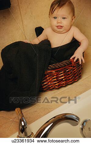 Baby sitting in bathroom basket View Large Photo Image Picture - Baby sitting in bathroom basket. Fotosearch