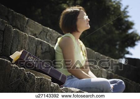 Bible in foreground with woman in background View Large Photo Image Stock Image - Bible in foreground with woman in background. Fotosearch