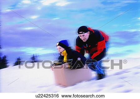 Boy in box being pushed downhill by man View Large Photo Image Stock Photograph - Boy in box being pushed downhill by man. Fotosearch