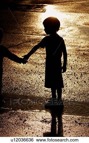 Boy standing in water puddle View Large Photo Image Stock Photograph - Boy standing in water puddle. Fotosearch