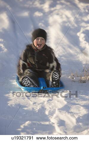 Stock Image - Boy tobogganing. Fotosearch