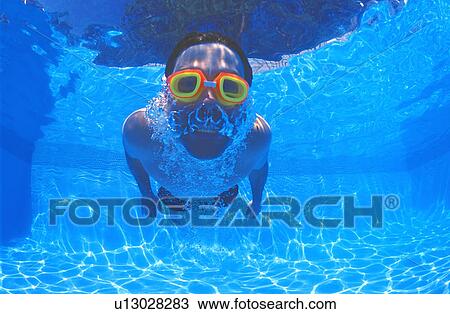 Stock Image - Boy with goggles in swimming pool. Fotosearch