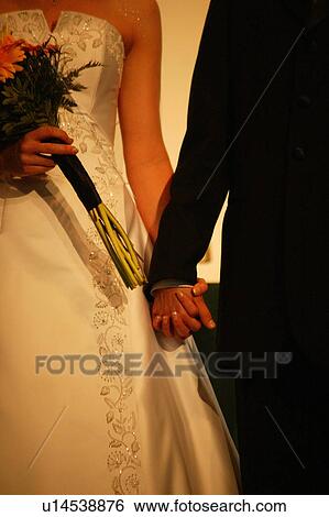 Stock Photograph - Bride and groom holding hands. Fotosearch