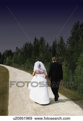 Bride and groom walking on path View Large Photo Image Stock Photo - Bride and groom walking on path. Fotosearch