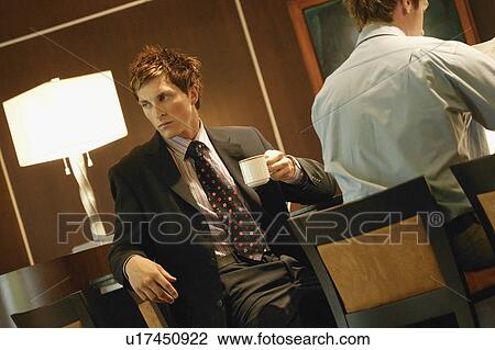 Stock Image - Businessman drinks coffee. Fotosearch