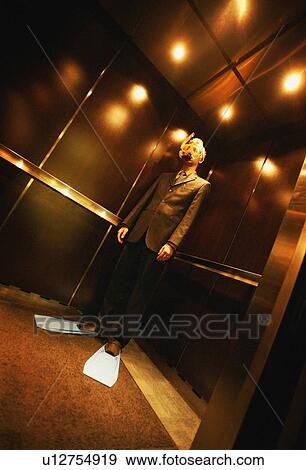 Businessman with snorkel & flippers on in elevator View Large Photo Image Stock Photo - Businessman with snorkel & flippers on in elevator. Fotosearch
