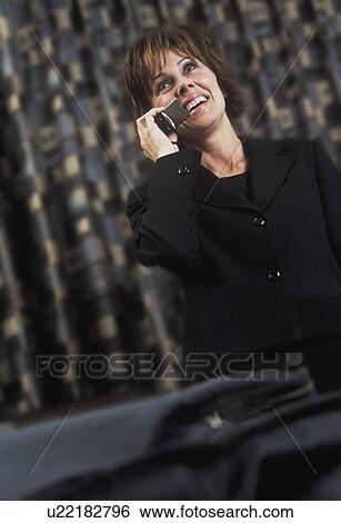 Stock Photograph - Businesswoman having fun phone conversation. Fotosearch