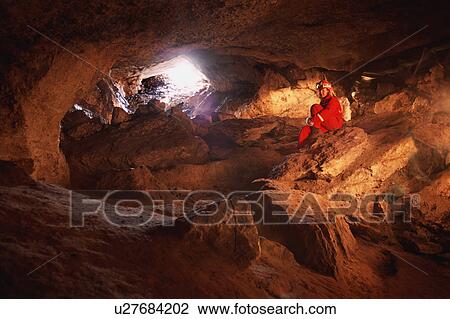 Stock Image - Cave interior and woman caver. Fotosearch