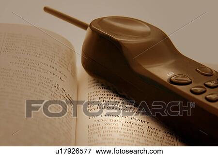 Cell phone and an open Bible View Large Photo Image Stock Photo - Cell phone and an open Bible. Fotosearch