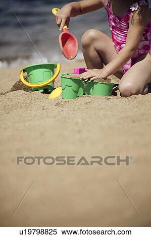 Stock Photography - Child playing in the sand. Fotosearch