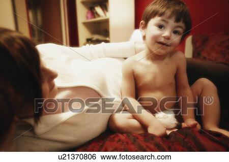 Child sitting on bed View Large Photo Image Stock Photograph - Child sitting on bed. Fotosearch