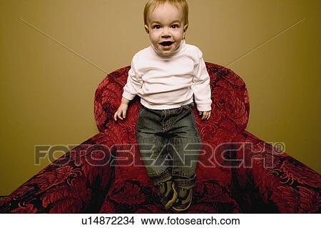 Picture - Child stands on chair. Fotosearch