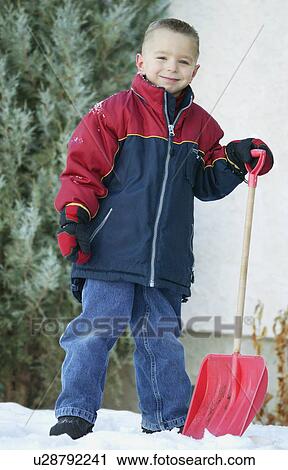 Stock Image - Child with snow shovel. Fotosearch