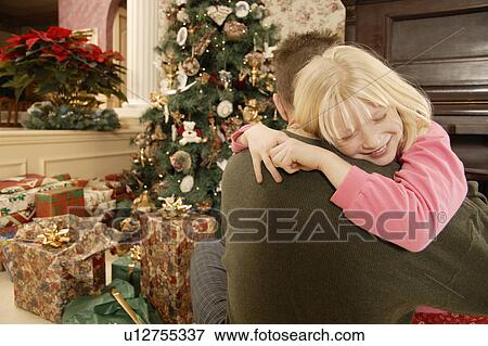 Stock Photo - Christmas morning hug. Fotosearch