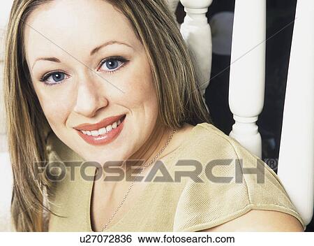 Stock Photograph - Closeup of woman sitting by banister. Fotosearch