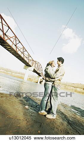 Stock Photography - Couple embrace in river valley. Fotosearch