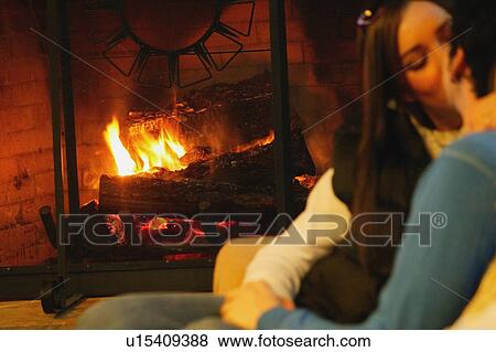 Stock Photo - Couple kiss in front of fireplace. Fotosearch