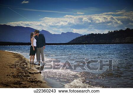 Stock Image - Couple kisses on the beach. Fotosearch