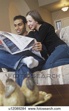 Couple reading the newspaper together View Large Photo Image Picture - Couple reading the newspaper together. Fotosearch